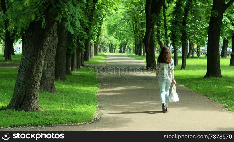 young women walking on the beautiful park with many green trees