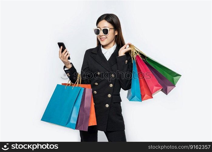 Young women wear glasses and shop on smart phones