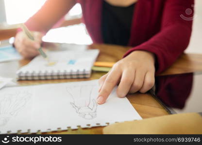 young women working as fashion designer drawing sketches for clothes in atelier paper at workplace studio