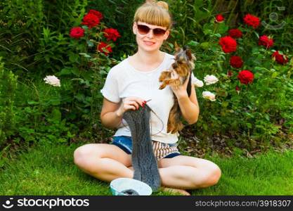 young wooman with needlework and dog in garden