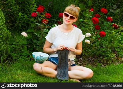 young wooman with needlework in garden