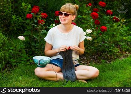 young wooman with needlework in garden