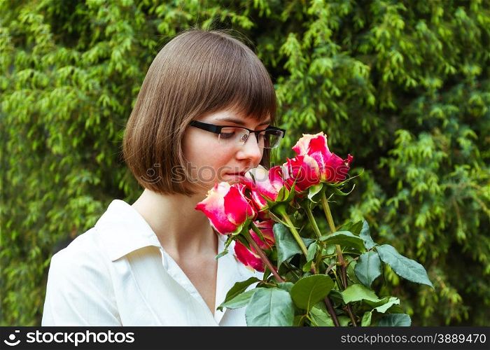 young wooman with scarlet roses on coniferous background