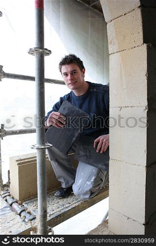 Young worker refurbishing a building