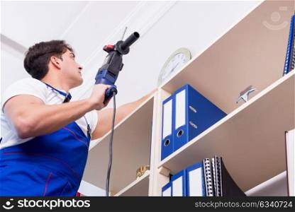Young worker repairing shelves in office