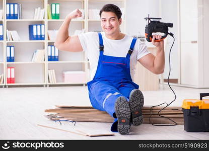 Young worker working on floor laminate tiles