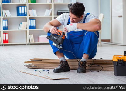 Young worker working on floor laminate tiles