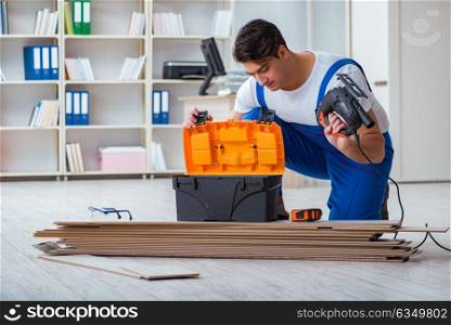 Young worker working on floor laminate tiles