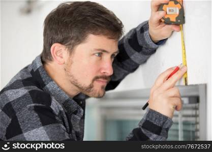 young working man measures with tape