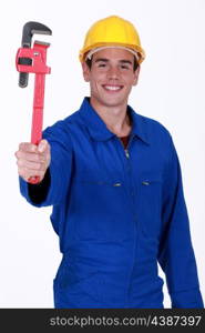 young workman in jumpsuit holding adjustable spanner