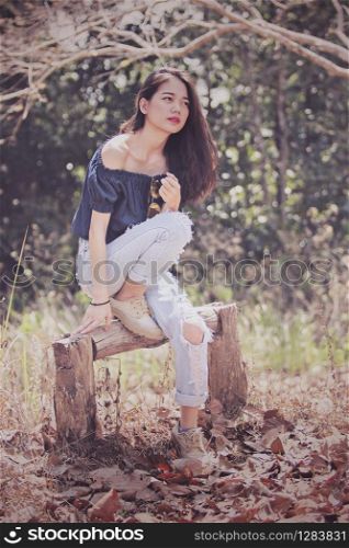 younger asian fashion model woman pose for photography in dry leaves forest