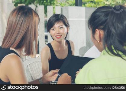 younger asian woman friend talking with relaxing at home living terrace