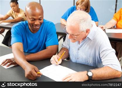 Younger college student tutors mature older student who is struggling to keep up. Focus on the tutor.