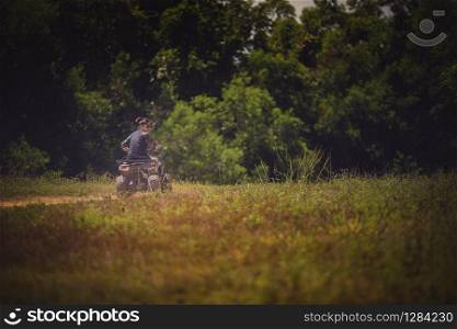 younger woman riding on sport quad tv vehicle on country field