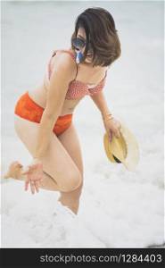 younger woman wearing bikini suit playing with happiness emotion on summer vacation beach