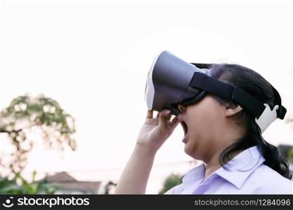 younger woman wearing virtual reality glasses with surprising face standing outdoor