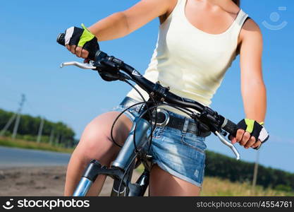 Your active lifestyle position. Young sporty girl with backpack riding bicycle along roadside