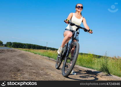 Your active lifestyle position. Young sporty girl with backpack riding bicycle along roadside