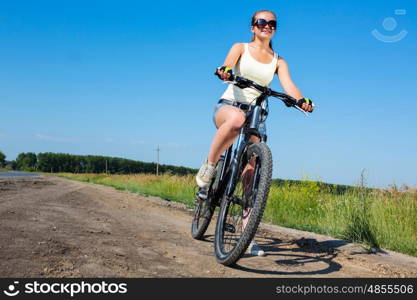 Your active lifestyle position. Young sporty girl with backpack riding bicycle along roadside