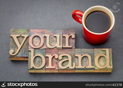 your brand banner - word abstract in letterpress wood type blocks againt slate rock with a cup of coffee