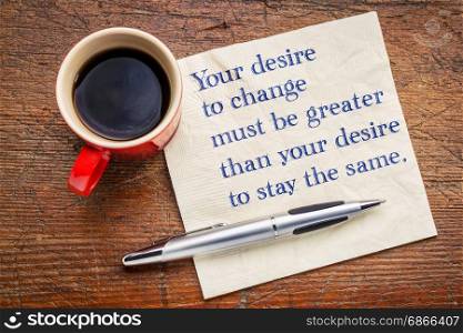 Your desire to change must be greater than your desire to stay the same - inspirational handwriting on a a napkin with a cup of coffee