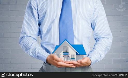 Your dream house. Close up of businessman holding house model in hands