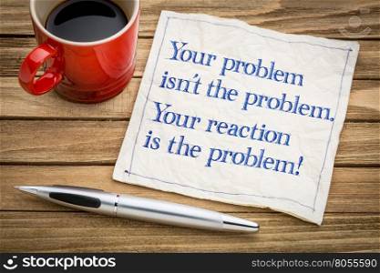 your problem is not the problem. Your reaction is the problem. Inspirational handwriting on a napkin with a cup of coffee.