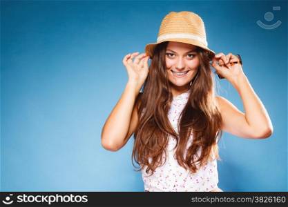Youth and vacation concept. Happy teen girl in summer clothes and straw hat. Portrait of smiling beauty woman tourist on blue.