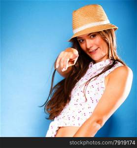 Youth and vacation concept. Happy teen girl in summer clothes and straw hat having fun. Portrait of smiling beauty woman tourist on blue.