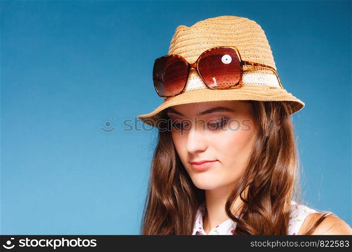 Youth and vacation concept. Lovely teen girl in summer straw hat and sunglasses. Portrait of beauty woman tourist on blue.