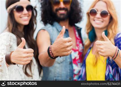youth culture, gesture and people concept - smiling young hippie friends in sunglasses showing thumbs up hand sign outdoors. happy young hippie friends showing thumbs up