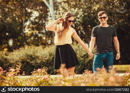 Youthful couple spending time together.. Love romance relationship dating leisure.Youthful couple spending time together. Young girl and boy olding hands in park.