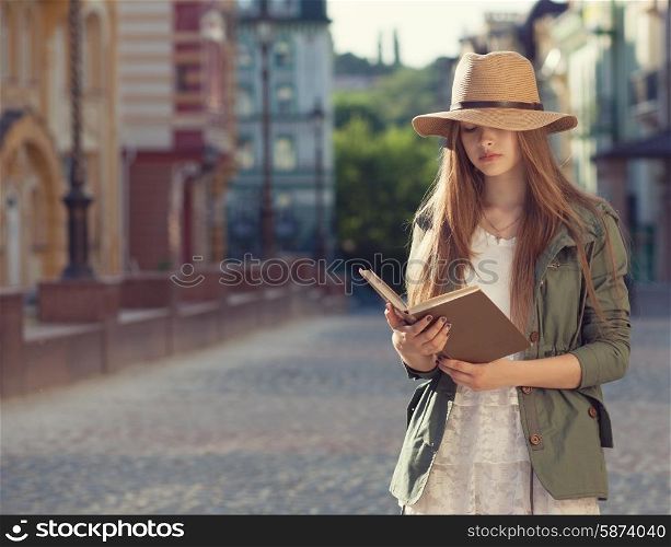 Yuccie girl reading book outdoors