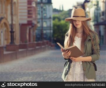 Yuccie girl reading book outdoors