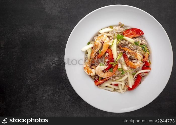 Yum Woon Sen, Thai food, Thai Glass Noodle Salad in white ceramic plate on dark tone texture background with copy space for text, top view