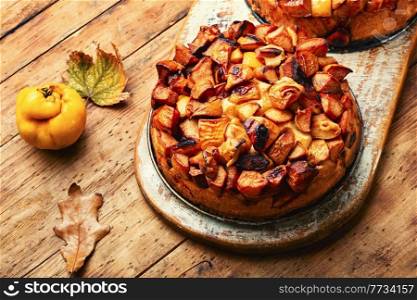 Yummy autumn pie or tart with quince on rustic wooden table. Autumn cake with quince