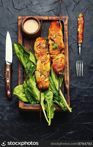 Yummy chicken fillet, souvlaki roasted on wooden skewers. Kebabs on cutting board. Chicken shish kebab or skewers