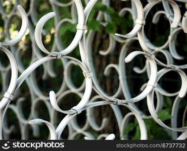 Zaunschnoerkel. squiggles of a white metal fence
