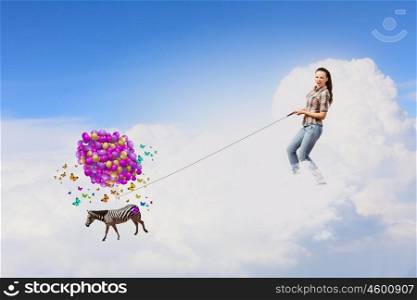 Zebra on lead. Young woman in casual and zebra flying in sky