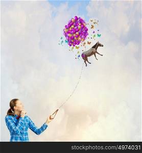 Zebra on lead. Young woman in casual and zebra flying in sky