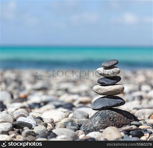 Zen meditation background - balanced stones stack close up on sea beach