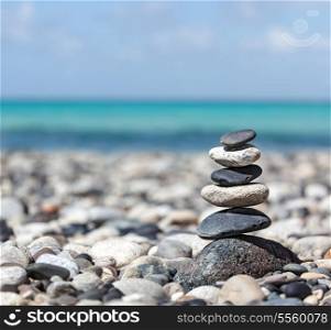 Zen meditation background - balanced stones stack close up on sea beach