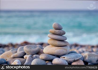 Zen meditation relaxation concept background - balanced stones stack close up on sea beach. Zen balanced stones stack on beach