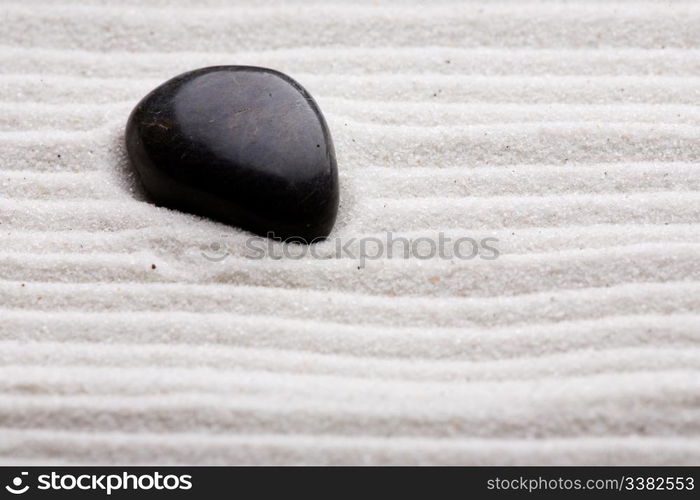 Zen rock garden with rows of white sand.