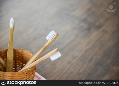 Zero waste bathroom use less plastic concept / bamboo toothbrush in basket eco natural plastic free items on rustic background
