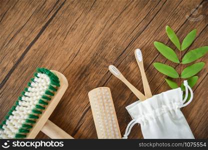 Zero waste Bathroom use less plastic concept / Floor brush , bamboo toothbrush and cotton cloth bag eco natural plastic free items and green leaf on rustic background
