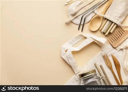 Zero waste concept. Cotton bag, bamboo cultery, glass jar, bamboo toothbrushes, hairbrush and straws on color background, flat lay, copyspace. Plastic free. Sustainable lifestyle concept.