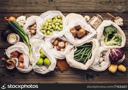 Zero waste concept. Eco bags with fruits and vegetables, glass jars with beans, lentils, pasta. Eco-friendly shopping and cooking concept, flat lay