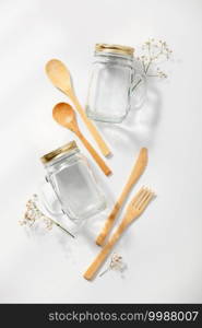 Zero waste, eco friendly concept. Glass jars and bamboo cutlery on white background. Flat lay, top view