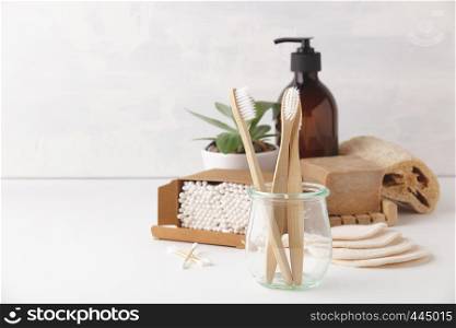 Zero waste, Recycling, Sustainable lifestyle concept. Eco-friendly bathroom accessories: toothbrushes, reusable cotton make up removal pads, make up remover in a glass container, natural brushes, handmade soap, bamboo ear sticks. Zero waste concept. Eco-friendly bathroom accessories, copyspace